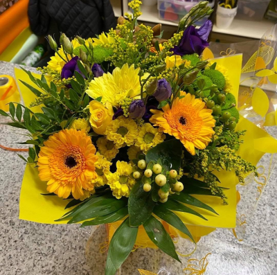 Golden Sunshine - A vibrant bouquet of sunny yellow and orange tones with rich purple accents and fresh greenery.