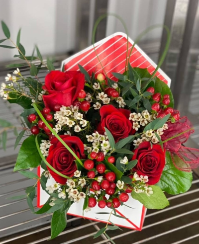 Love Letter - A romantic envelope arrangement in rich red tones, complemented by delicate white accents and fresh greenery.