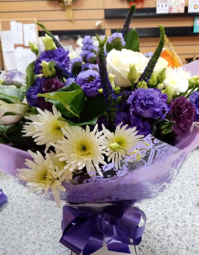 Purple Elegance - A graceful bouquet in rich purple and crisp white tones, complemented by fresh green foliage.